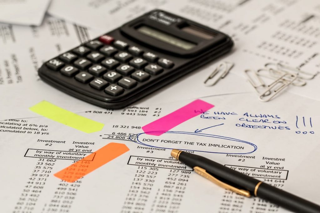 Calculator and expenses listed to file business taxes